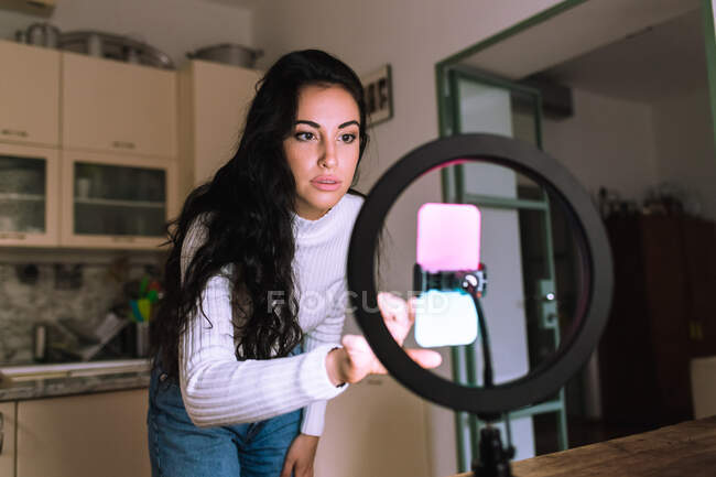Jeune femme utilisant un téléphone portable avec anneau lumineux — Photo de stock