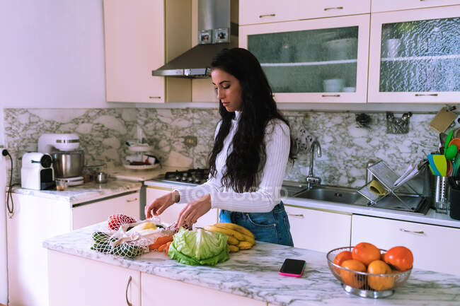 Mulher desembalar legumes na cozinha — Fotografia de Stock