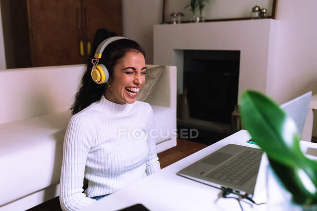 Молода жінка на відео дзвонить по ноутбуку, сміється — стокове фото