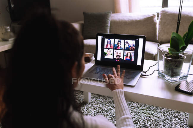 Mujer joven en videollamada en el ordenador portátil en casa - foto de stock