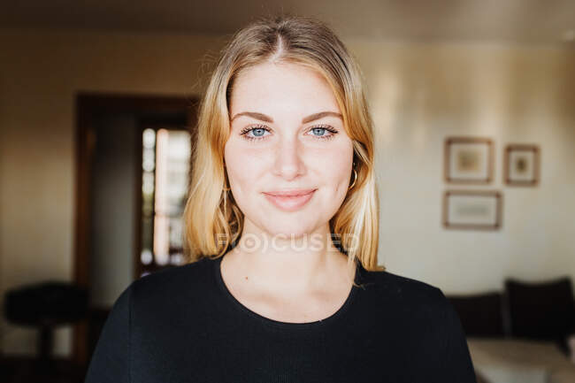 Head and shoulders portrait of young woman at home — Stock Photo