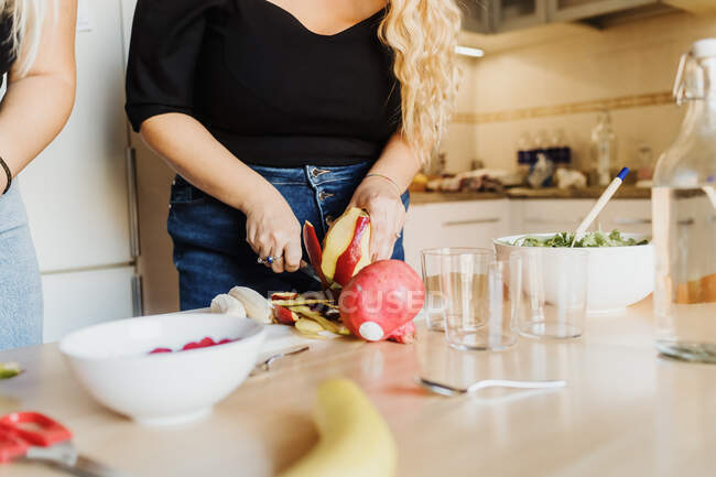 Mujer preparando fruta, vista recortada - foto de stock