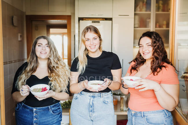 Três jovens mulheres tomando café da manhã juntas — Fotografia de Stock