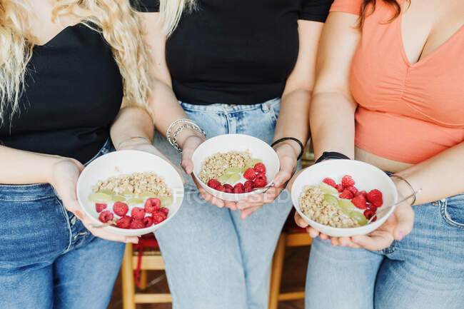 Три женщины держат здоровые миски для завтрака, обрезанные — стоковое фото