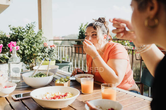 Друзі їдять їжу на балконі — стокове фото