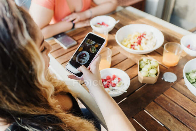 Young woman taking picture of healthy breakfast — Stock Photo