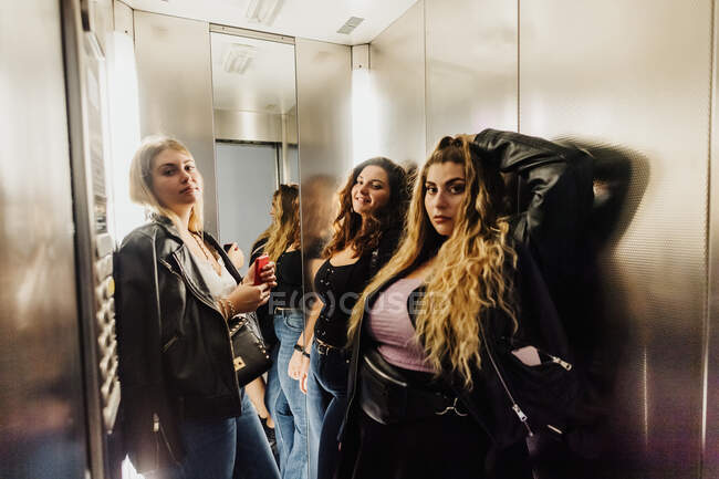 Three young women in elevator — Stock Photo