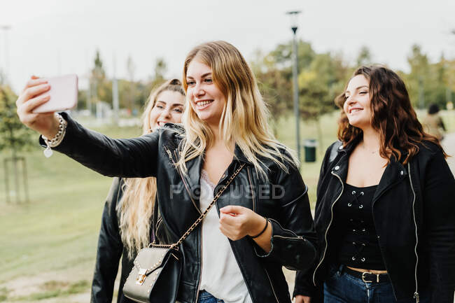 Friends taking selfie on phone outdoors — Stock Photo