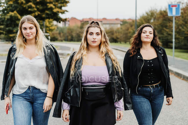 Три друзі-жінки, що йдуть по дорозі — стокове фото
