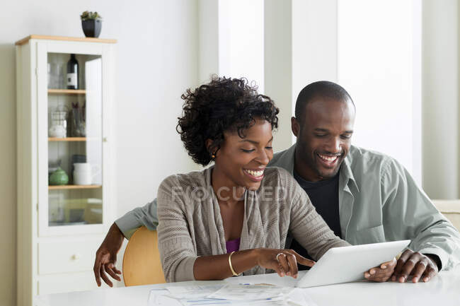 Mid adult couple using digital tablet — Stock Photo