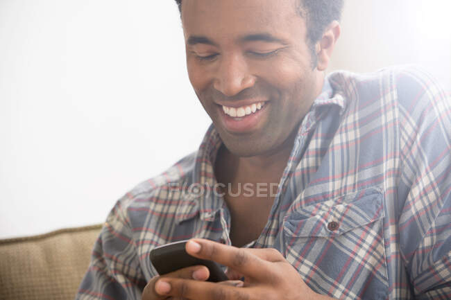 Homme souriant utilisant Smartphone — Photo de stock