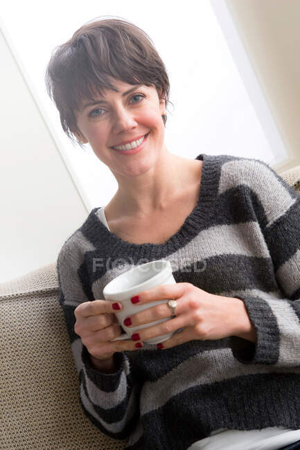 Femme moyenne adulte tenant du café — Photo de stock