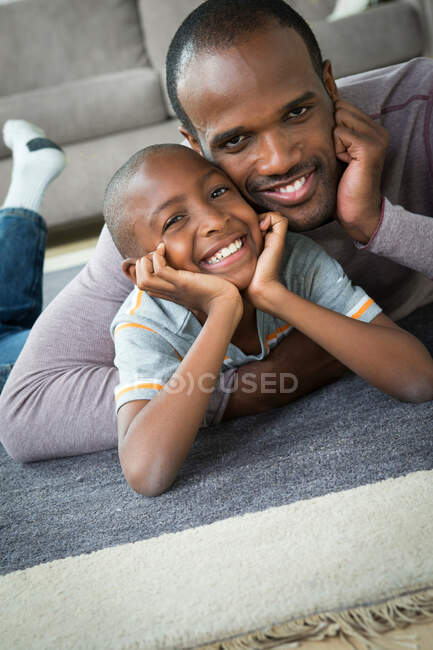 Батько і син лежать на підлозі — стокове фото