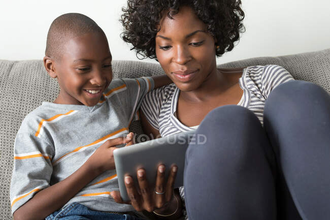 Mère et fils utilisant une tablette numérique — Photo de stock