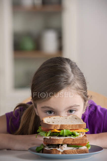 Chica mirando el sándwich - foto de stock
