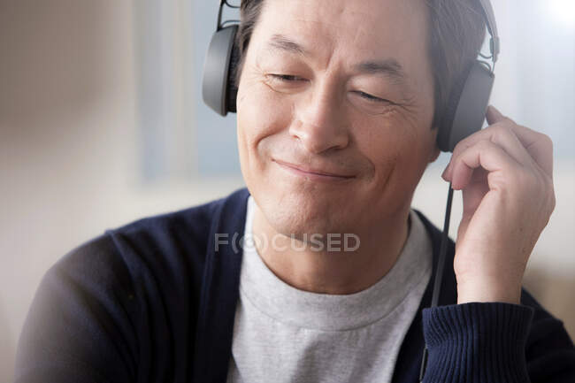 Mature asiatique homme portant des écouteurs — Photo de stock