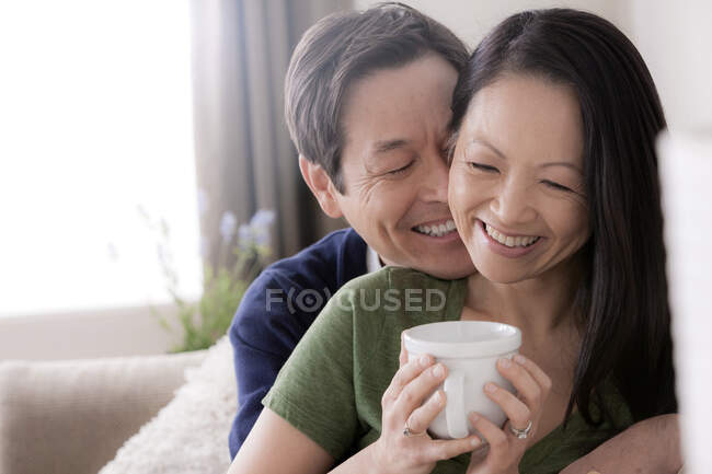 Зріла пара посміхається, жінка з кавою — стокове фото