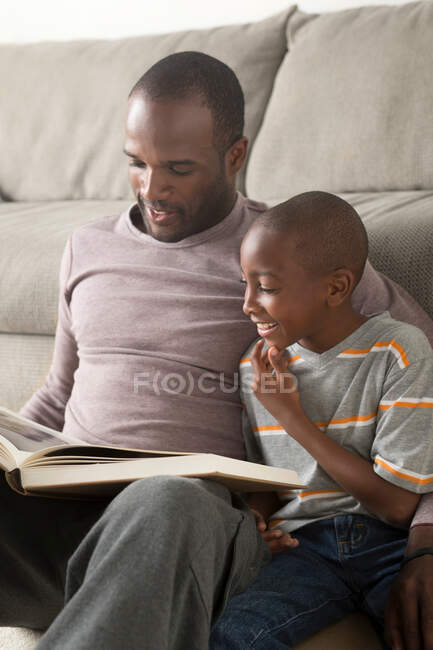 Padre e hijo leyendo libro - foto de stock