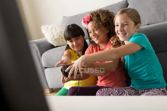 Three girls playing video game — Stock Photo