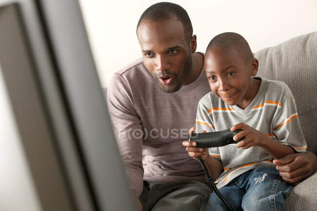 Père et fils jouant au jeu vidéo — Photo de stock