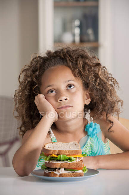 Дівчина дивиться вгору з бутербродом — стокове фото