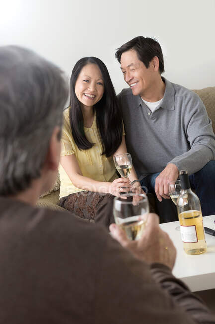 Зрелые друзья общаются с белым вином — стоковое фото