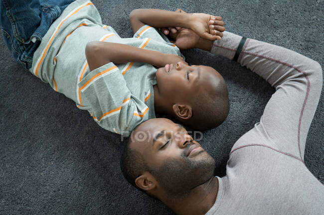 Padre e hijo durmiendo en el suelo - foto de stock