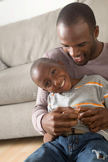 Portrait of son sitting on father's lap — Stock Photo