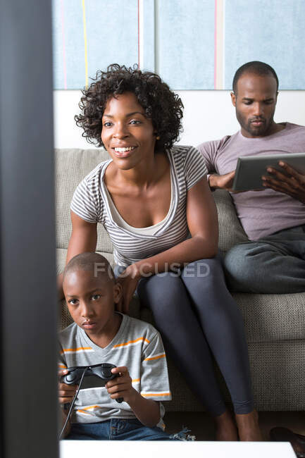 Garçon jouant jeu vidéo, mère regardant — Photo de stock