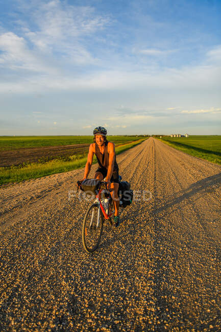 Man cycling through field, Ontário, Canadá — Fotografia de Stock