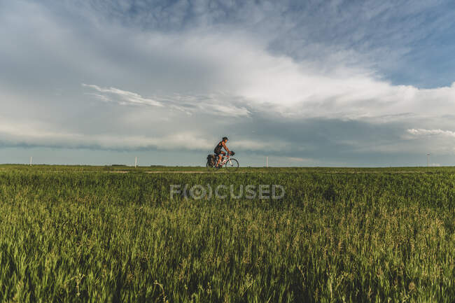 Man cycling through field, Ontário, Canadá — Fotografia de Stock