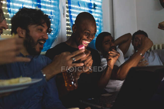 Hommes regardant le sport ensemble sur ordinateur portable, acclamant — Photo de stock