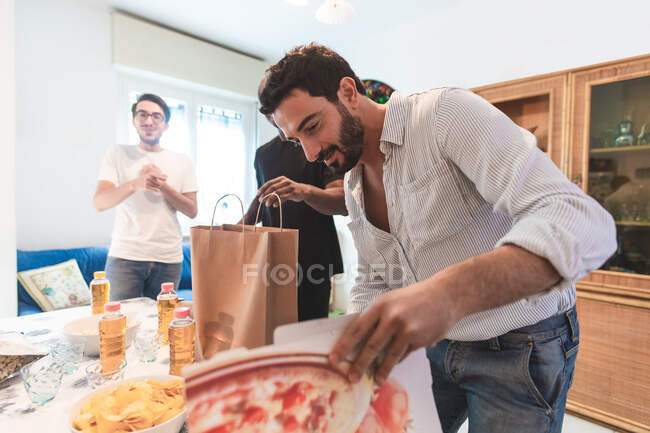 Man setting out takeaway food at home — Stock Photo