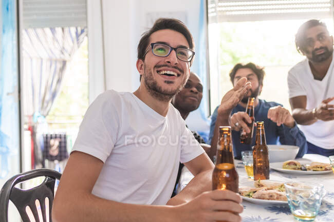 Amigos varones comiendo y tomando cerveza - foto de stock