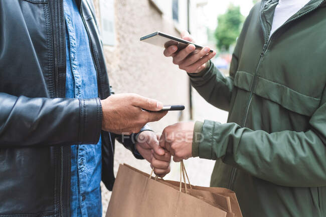 Picking up takeaway, using contactless payment on phones — Stock Photo