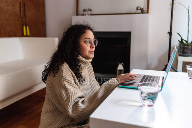 Молода жінка використовує ноутбук вдома — стокове фото