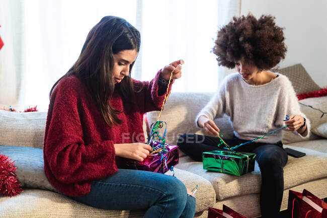 Mujeres envolviendo regalos en casa - foto de stock