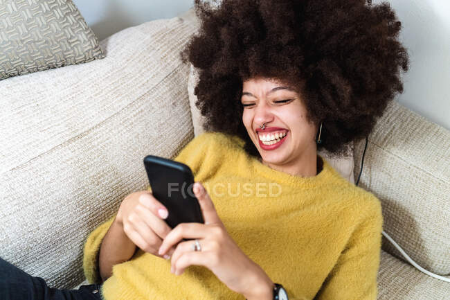 Young woman looking at phone and laughing — Stock Photo
