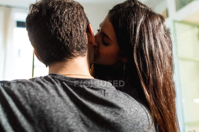 Молодая женщина целует парня — стоковое фото