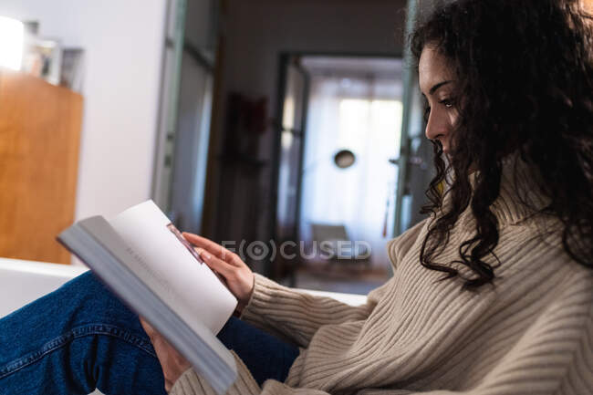 Junge Frau liest zu Hause — Stockfoto