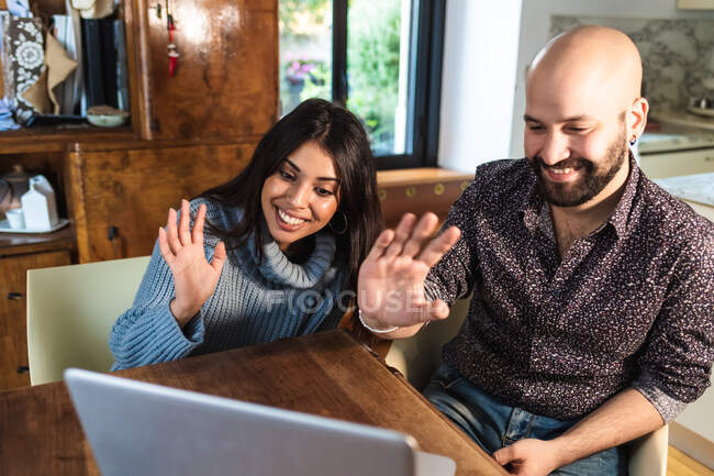 Couple on laptop video call, waving — Stock Photo
