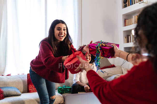 Друзі обмінюються подарунками вдома — стокове фото