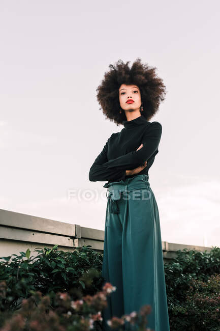 Portrait of a young woman outdoors, arms crossed — Stock Photo