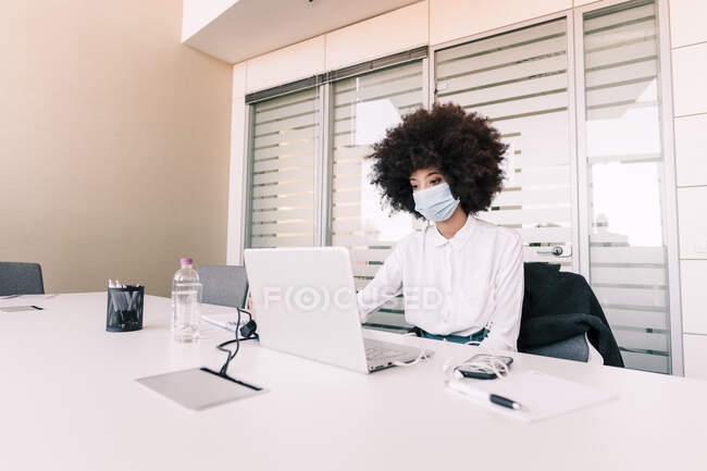 Деловая женщина в маске для лица во время работы — стоковое фото