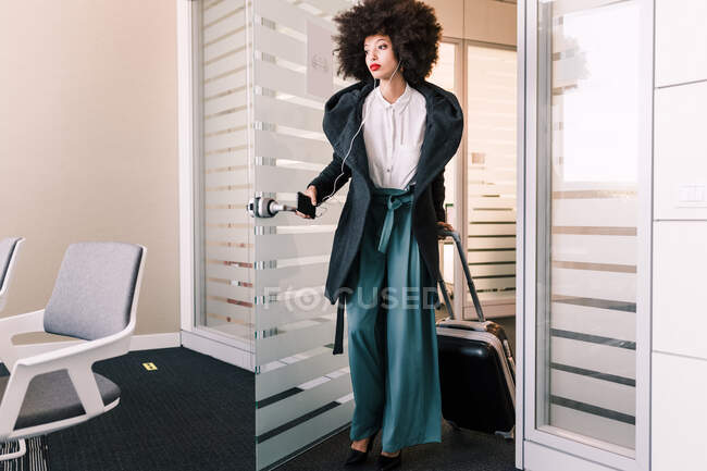 Бізнес-леді прибуває в офіс з валізою — стокове фото
