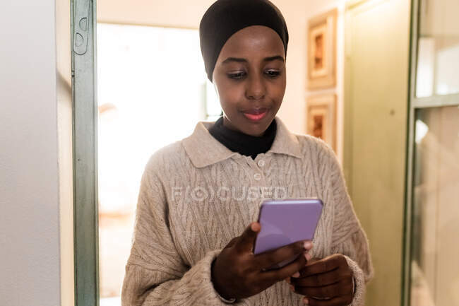 Молода жінка дивиться на свій телефон — стокове фото
