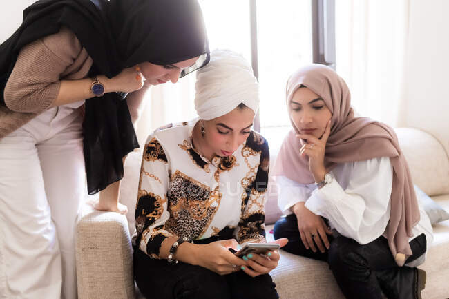 Amis féminins regardant le téléphone intelligent — Photo de stock