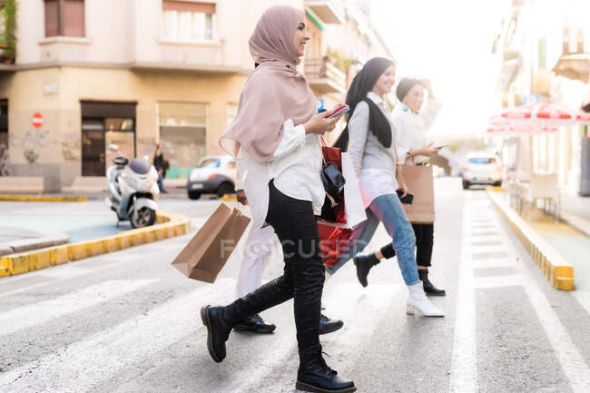 Молодые женщины в походе по магазинам, на перекрестке — стоковое фото