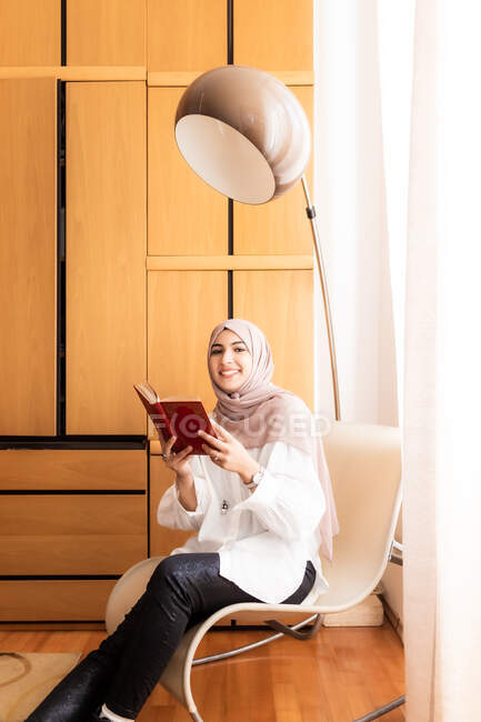 Молода муслівна жінка читає книжку. — стокове фото