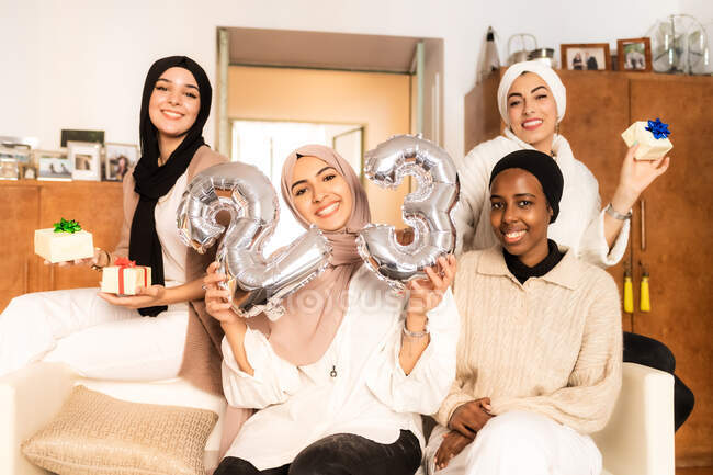 Friends with gifts and number 23 balloons — Stock Photo